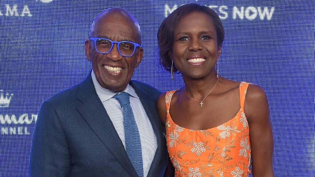 Al and Deborah Roker, in a blue suit and an orange dress respectively, pose on the red carpet