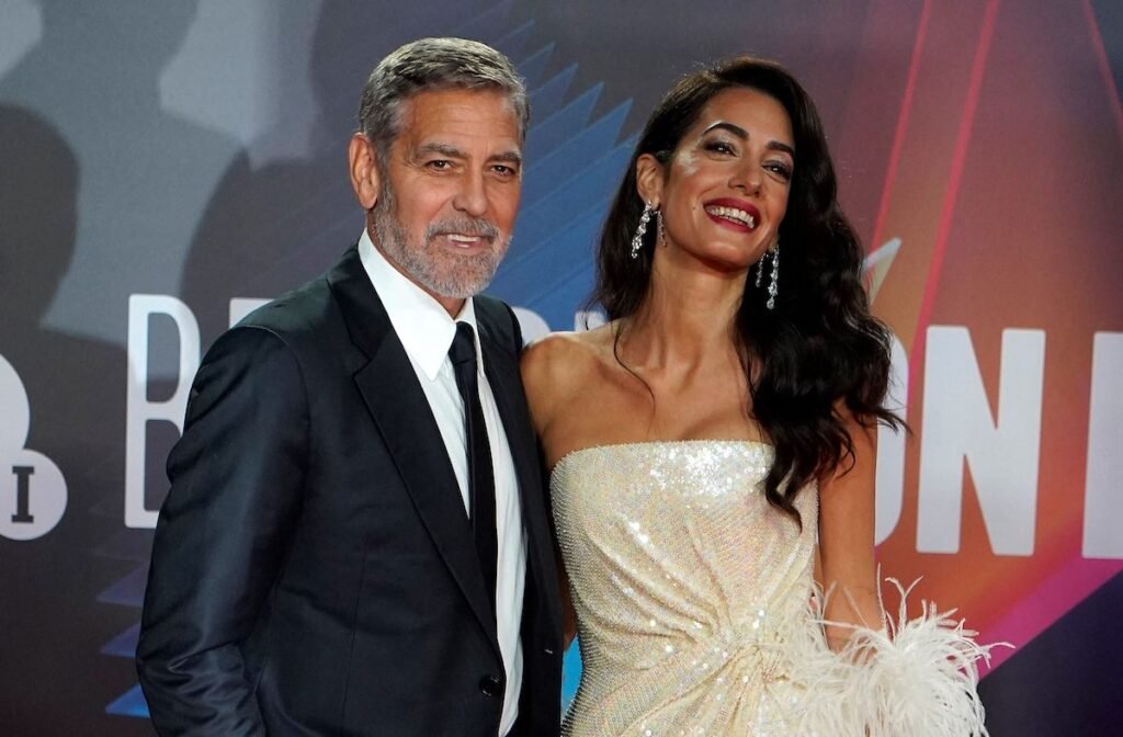 George Clooney in a black suit with AMal Clooney in a white dress