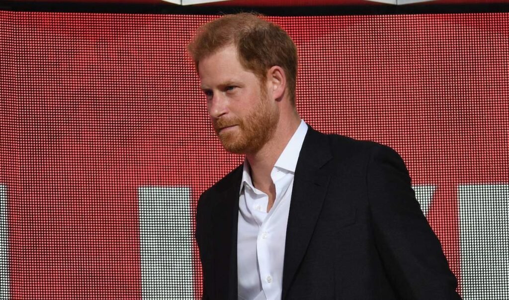 Prince Harry in a black coat and white shirt