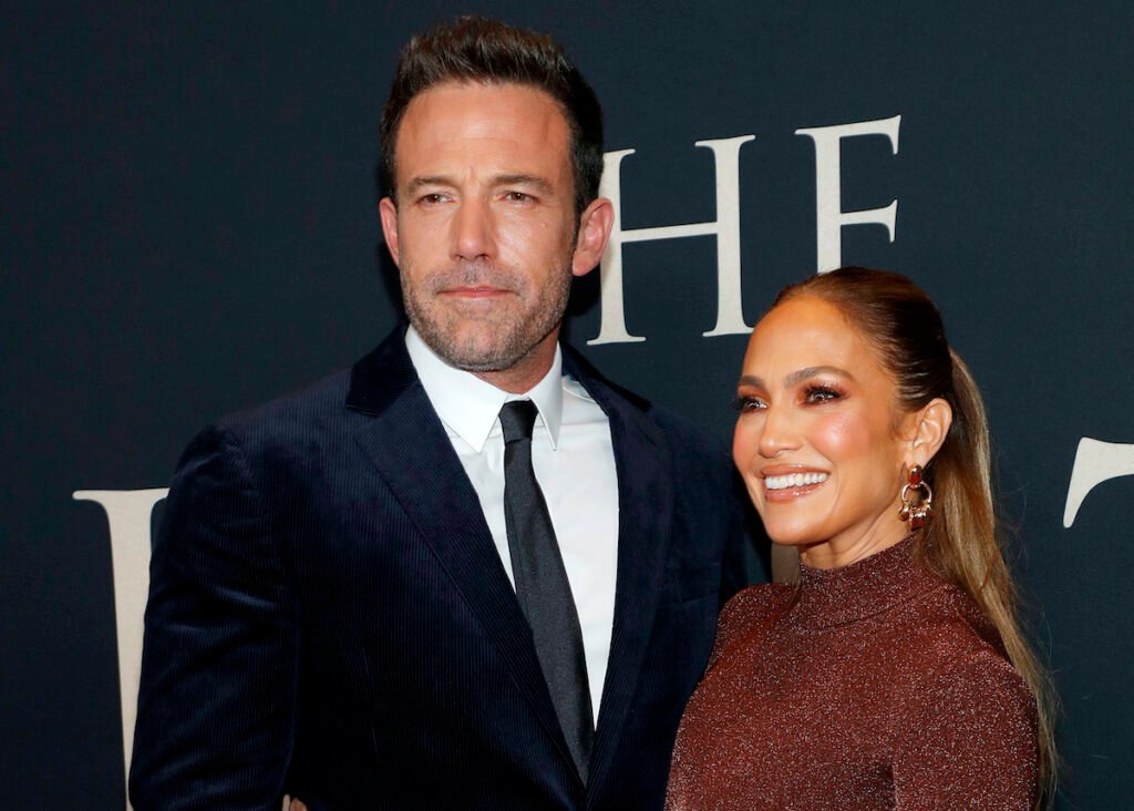 Ben Affleck in a navy suit and Jennifer Lopez in a brown dress