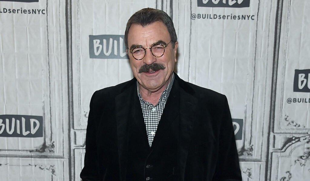 Tom Selleck smiling in a black jacket