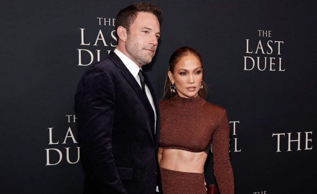 Ben Affleck in a black suit with Jennifer Lopez in a brown dress