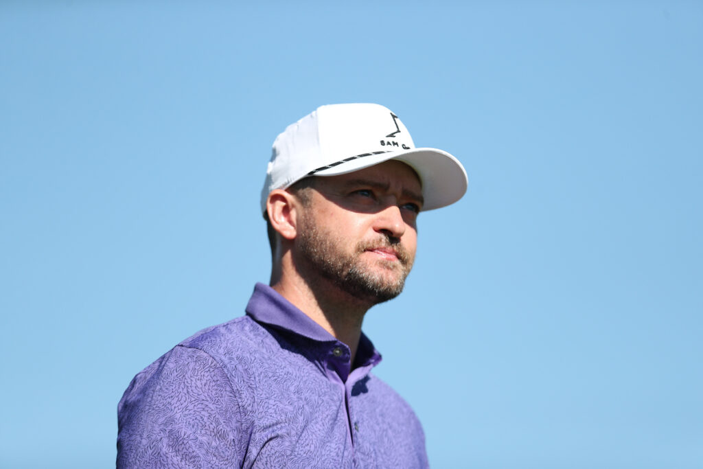 Justin Timberlake in a purple shirt and white hat