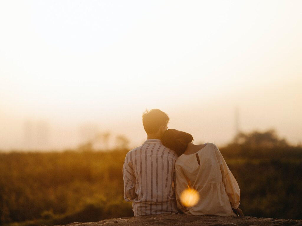 A couple sitting in a field together