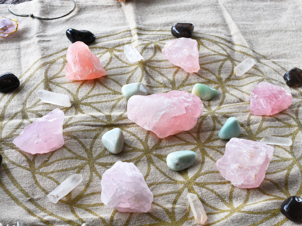 A close up image of a self love and self healing crystal grid using sacred geometry and rose quartz crystals.