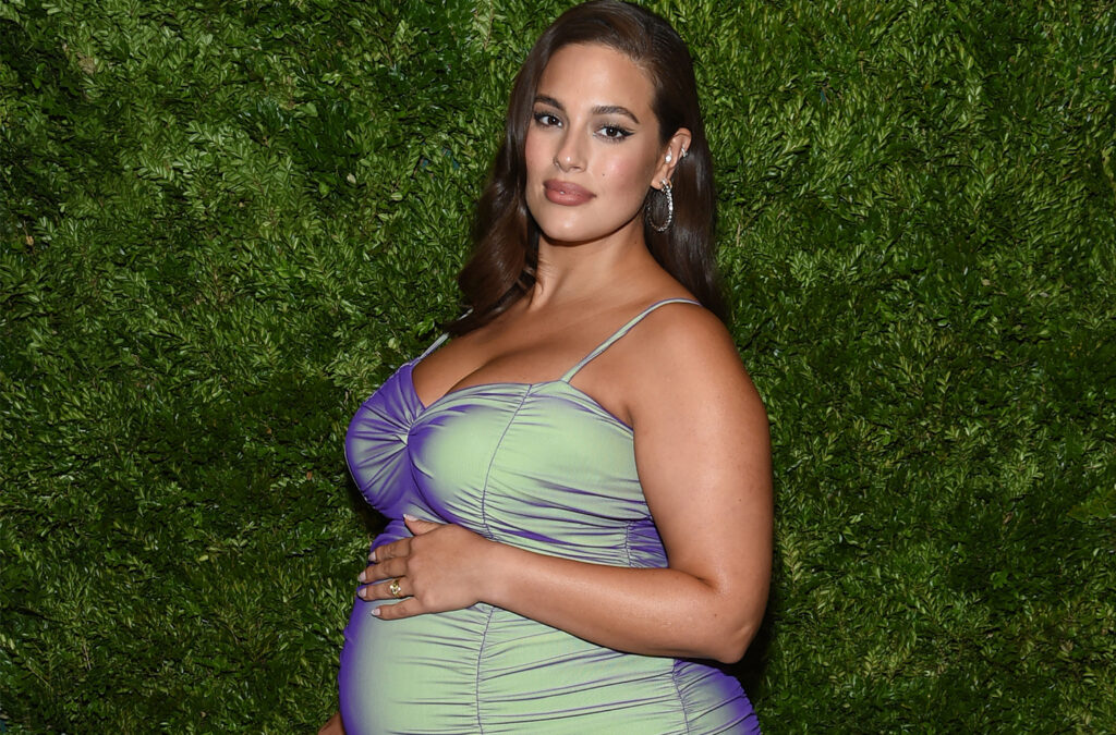 Ashley Graham, pregnant, in a green dress.