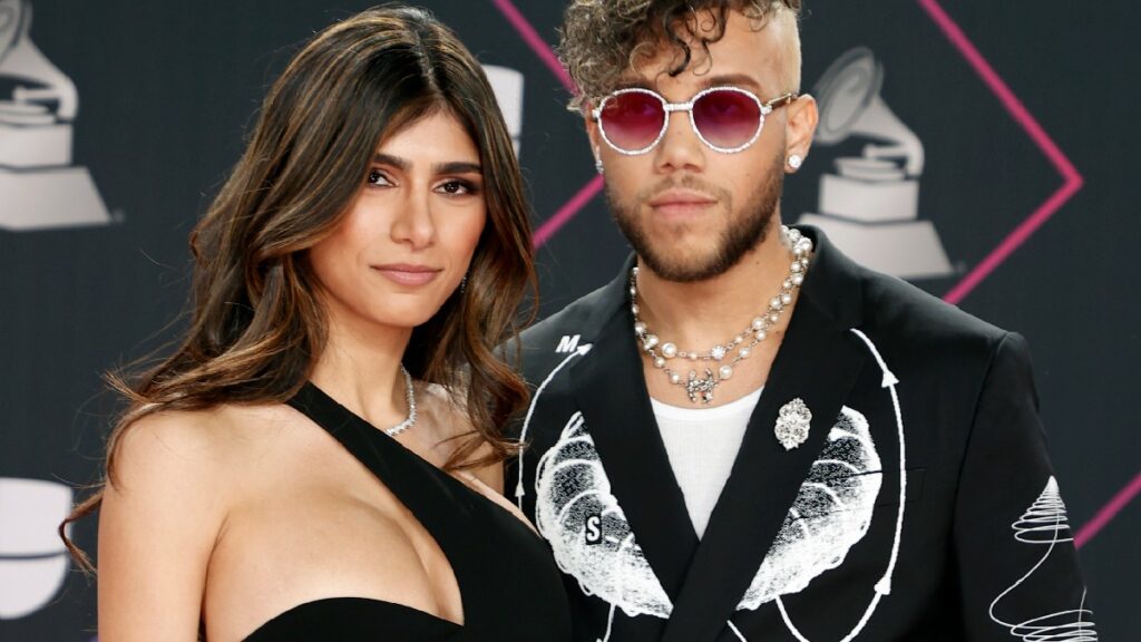 Mia Khalifa and Jhay Cortez, both dressed in black and white, pose on the red carpet