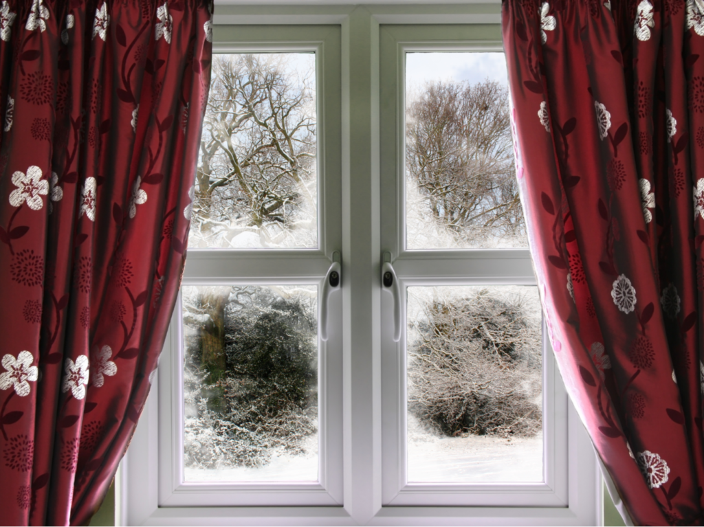 Winter view from a window through a red curtain