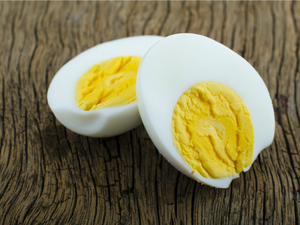 Peeled boiled egg on wooden background