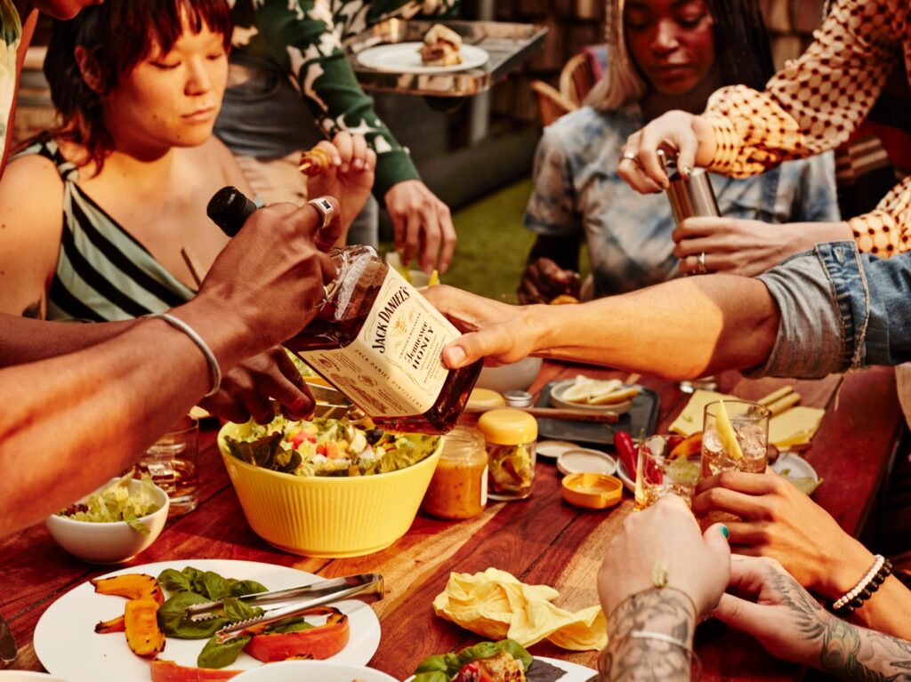 Group of friends at an outdoor BBQ enjoying Jack Daniel's Flavored Whiskey drinks.