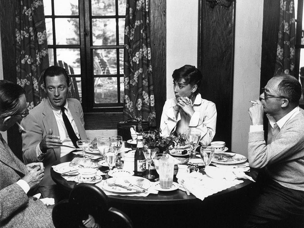 William Holden, Audrey Hepburn, and Billy Wilder taking a meal break on the set of 'Sabrina'.   