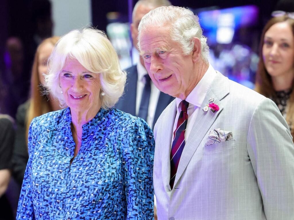 Camilla Parker Bowles in a blue dress and Prince Charles in a white suit