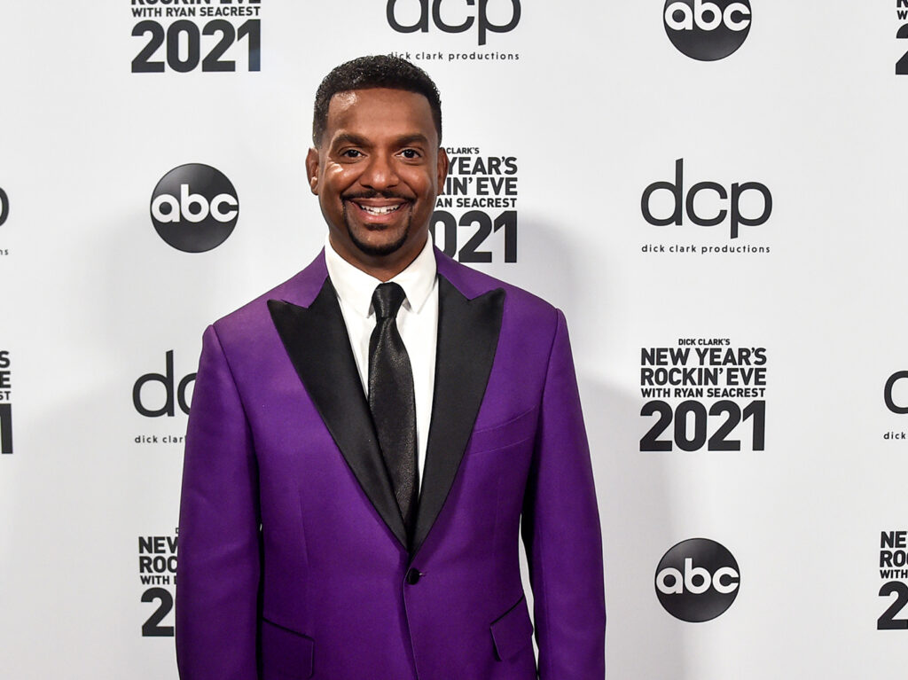 Alfonso Ribeiro smiling in a purple tuxedo