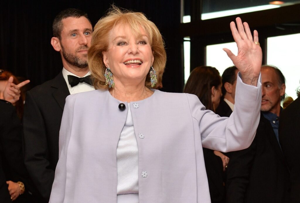 Barbara Walters smiles and waves at the 2014 WHCA annual dinner