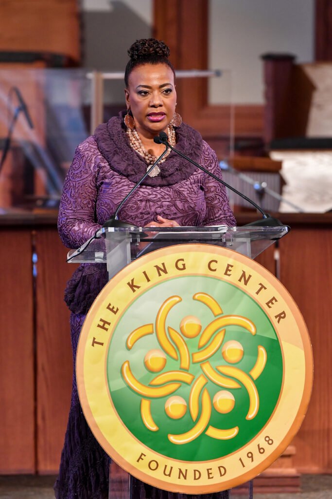 Bernice King in purple cowl neck sweater speaking at a podium