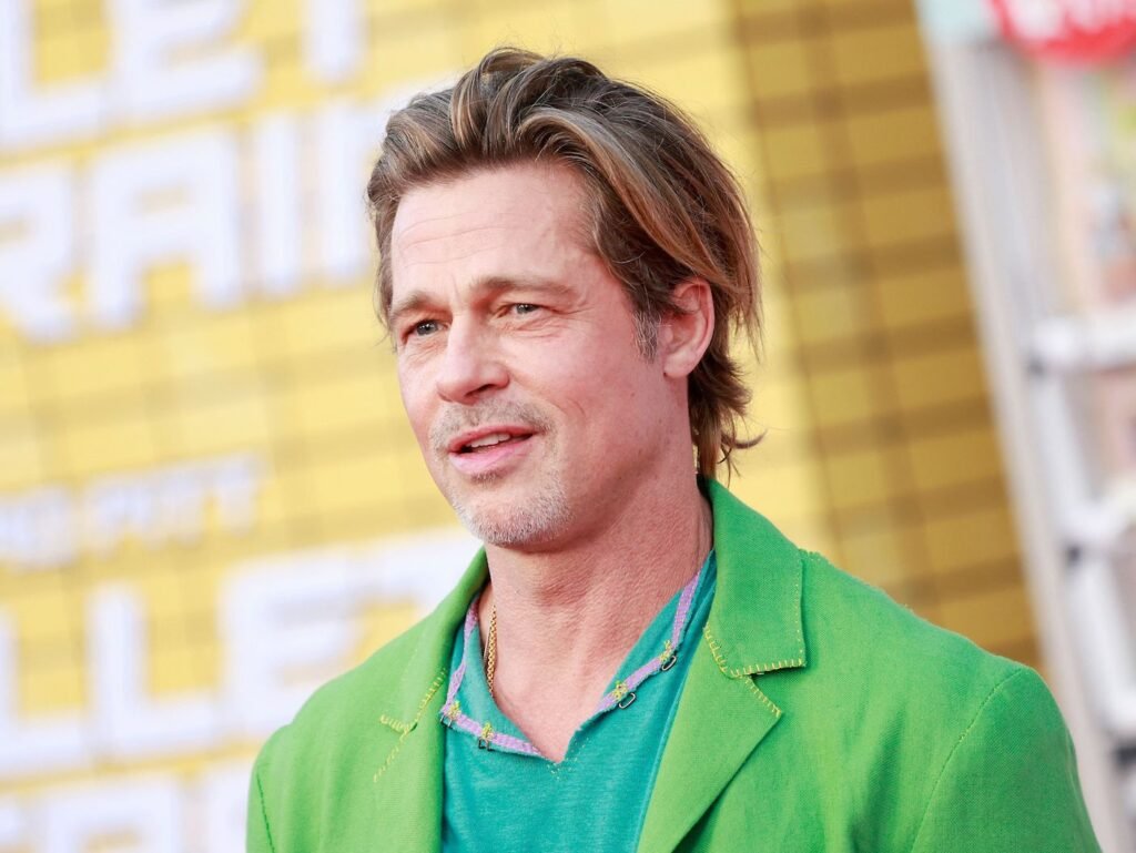 Brad Pitt smiling in a green suit