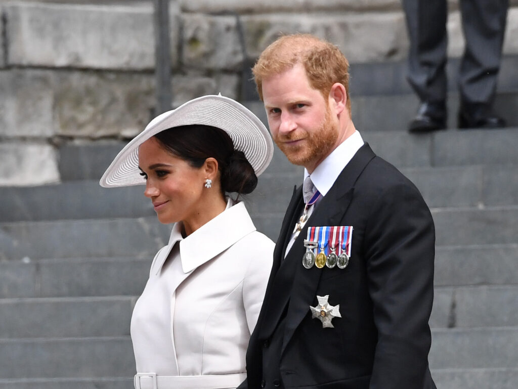 Meghan Markle in a white dress with Prince Harry in a black suit
