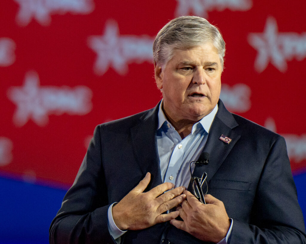 Sean Hannity in a navy suit speaking on stage