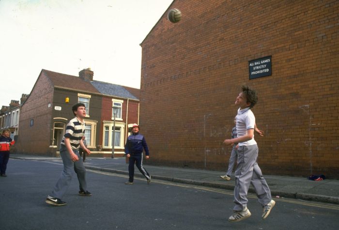 Children play game of soccer in the street