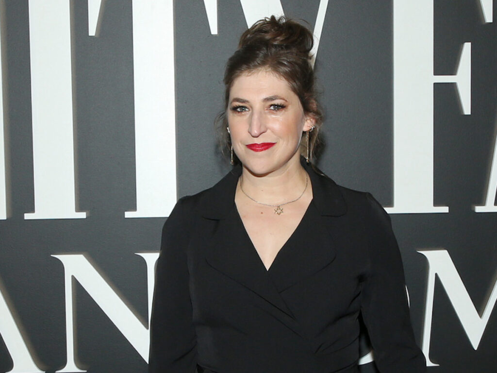 Mayim Bialik smiling in a black blouse