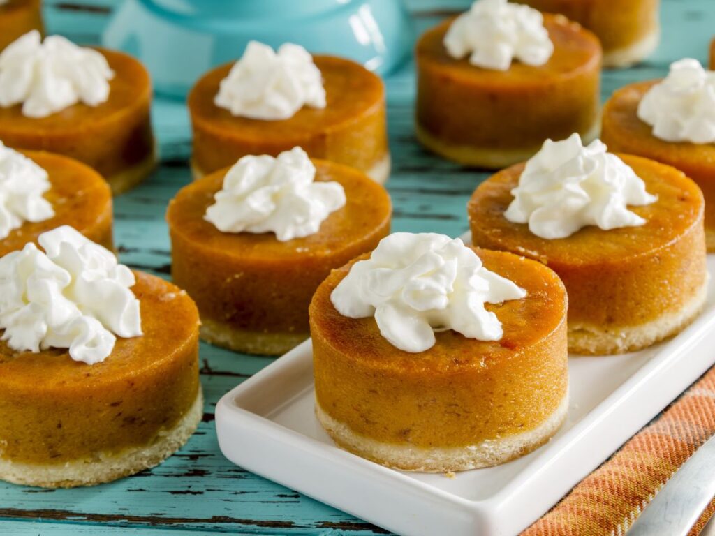 Mini pumpkin pies topped with dollops of whipped cream
