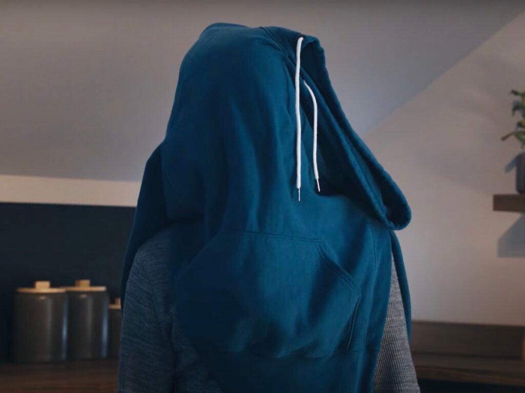 screenshot of a man with a blue hoodie draped over his head from a Downy commercial